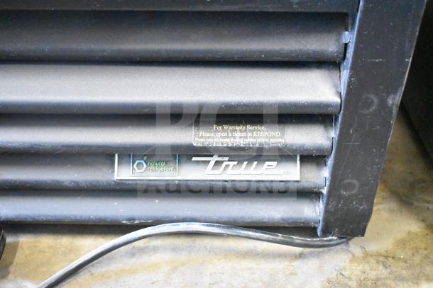2019 True GDM-49F-HC commercial freezer, black grill, "True" logo, natural refrigerant, warranty label visible.