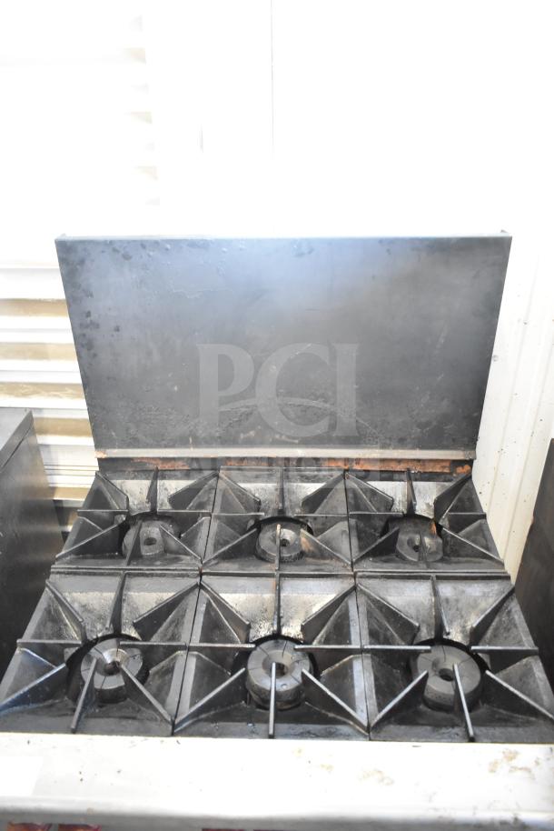 Wolf CHSSR-6-29 commercial gas range with 6 burners, oven, and backsplash. Used condition, visible wear on surfaces.