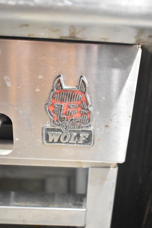 Wolf SCB25F-1 commercial charbroiler grill, natural gas-powered, missing grates, visible Wolf logo emblem.