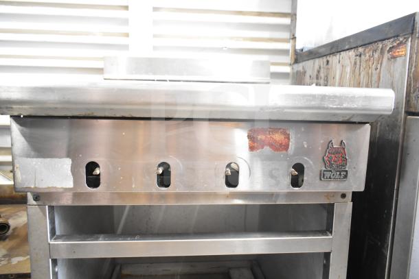 Wolf SCB25F-1 commercial gas charbroiler grill, missing grates. Features stainless steel exterior with visible branding.