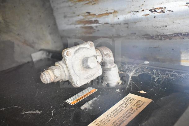 Wolf SCB25F-1 commercial gas charbroiler grill, missing grates, used condition, visible wear and cobwebs, model label shown.