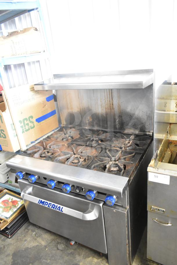 Imperial commercial gas-powered 6-burner range with oven, over shelf, and backsplash. Used condition.