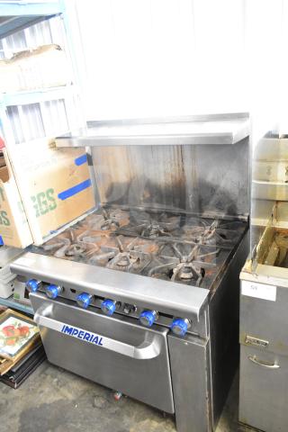 Imperial commercial gas-powered 6-burner range with oven, over shelf, and backsplash. Used condition.