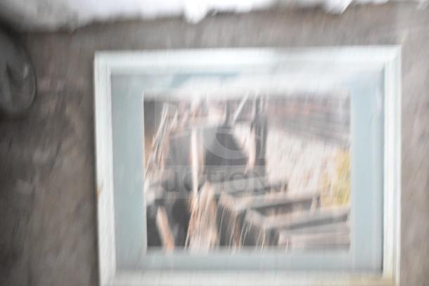 Blurry framed picture with a rustic image inside, featuring a white frame in worn condition. One of 29 framed pieces.