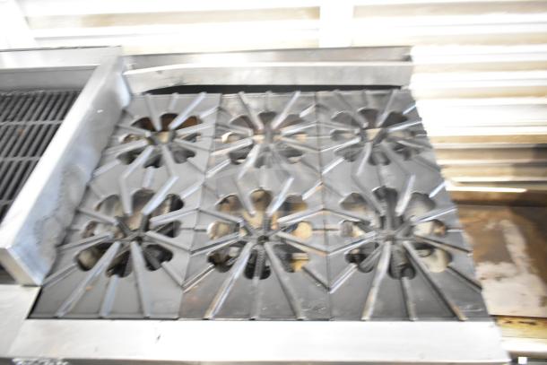 Montague UF-36R 6-burner range with charbroiler, natural gas, commercial casters, under shelves, good condition.