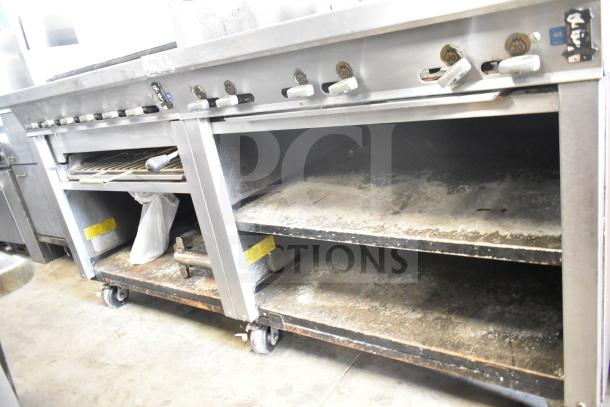 Montague UF-36R commercial gas range with 6 burners, left side charbroiler, under shelves, on casters. Moderate wear visible.