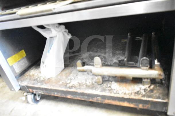 Montague UF-36R commercial gas range with 6 burners, left side charbroiler, undershelves, and casters, model UF-36R.