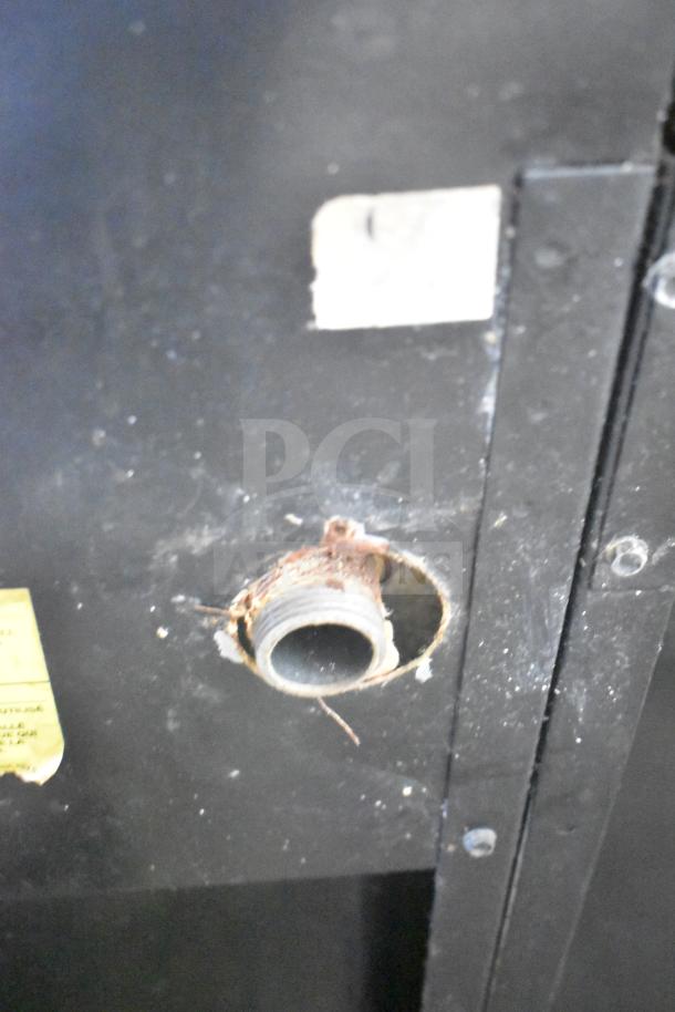 Close-up of Montague UF-36R commercial range connection point, showing natural gas fitting and partially visible labels.