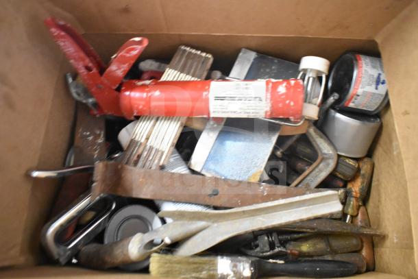 Lot of various items in a box, including red caulking gun, paintbrushes, metal tools, and cans, in used condition.
