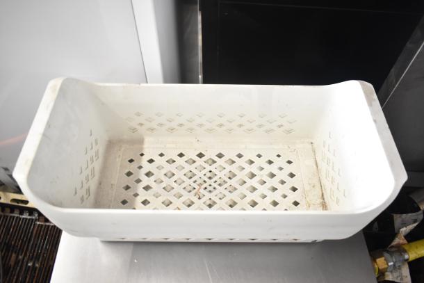 White poly basket with open grid design, part of a mixed lot including buckets, air pot, lights, paint rollers, and tools.