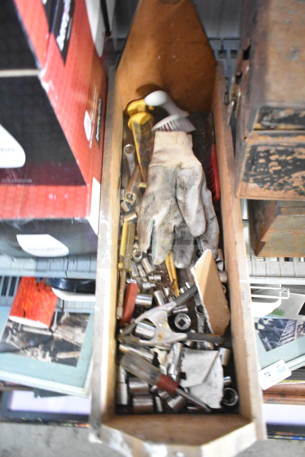 Lot of assorted tools including sockets, pliers, gloves, a clamp, and jumper cables in a wooden organizer; used condition.