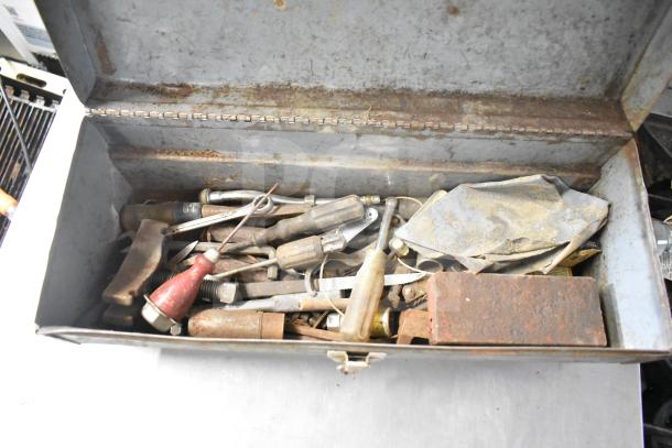 Lot of assorted tools in a metal toolbox, includes clamps, jumper cables, screwdrivers, and other hand tools, showing wear.