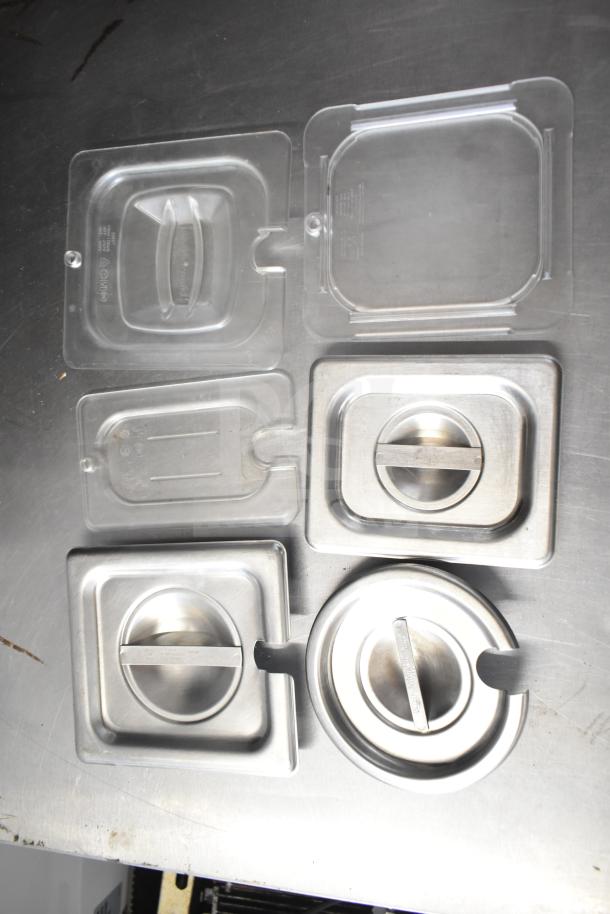 Assorted metal and plastic lids with handles, displayed on a metal surface. No visible markings or damage.