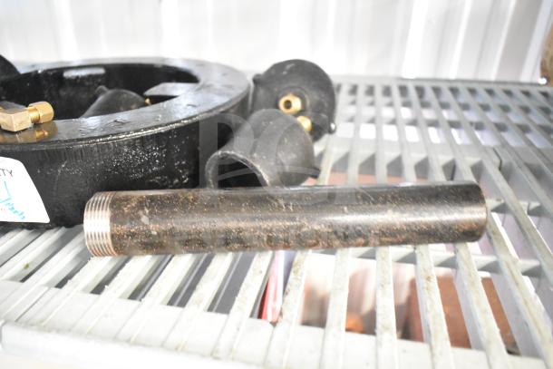 Black metal ring burner for range, includes threaded pipe attachment, in used condition with visible wear.