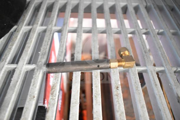 Ring burner for range, in metallic and brass, on a metal grid. Appears in good condition, suitable for stovetop use.