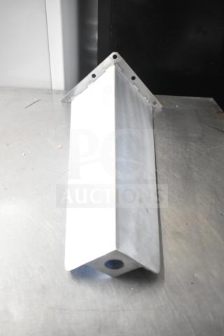 A triangular metal leg with mounting holes, brand new, placed on a metallic surface.
