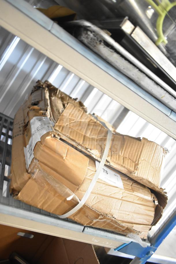 Damaged cardboard box labeled "BRAND NEW Legs" with visible straps and worn corners on a metal shelf.