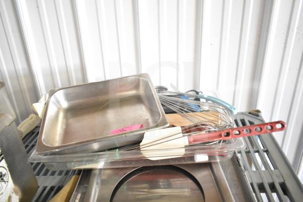 Lot of kitchen items including stainless steel drop-in bins, bowl, cutting board, utensils, round baking sheets with a pink label.
