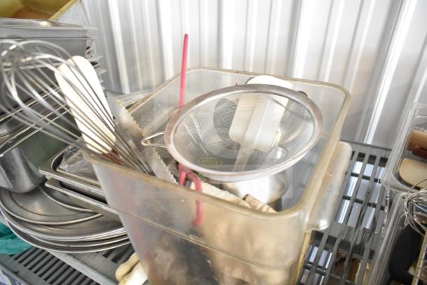 Lot of kitchen items including stainless steel drop-in bins, bowl, cutting board, utensils, and round baking sheets.