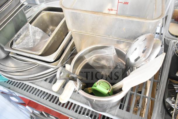 Lot of kitchen items including stainless steel drop-in bins, utensils, baking sheets, bowl, and cutting board.