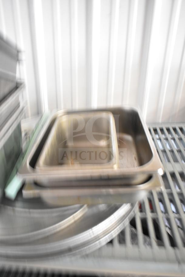 Lot of various kitchen items including stainless steel drop-in bins, round baking sheets, bowl, and cutting board.