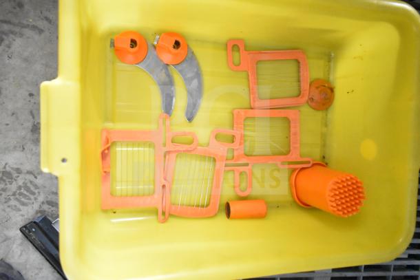 Countertop vegetable cutter with orange and stainless steel components. Includes various blade attachments in good condition.