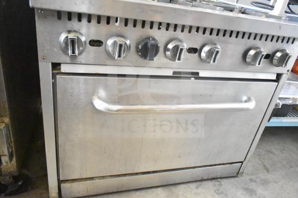 Commercial gas-powered 6 burner range with oven, over shelf, and backsplash. Stainless steel, used condition.