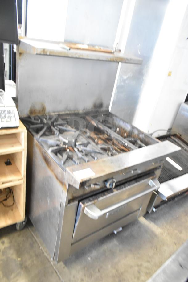 Garland Commercial 6 Burner Range with oven, over shelf, and backsplash; stainless steel; signs of use; suitable for restaurants.