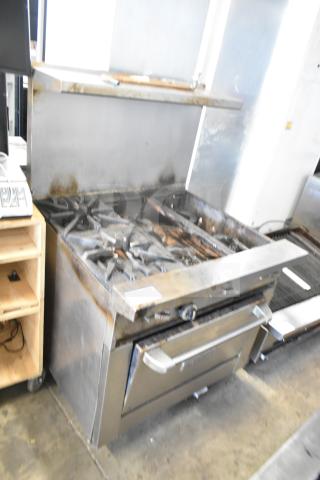 Garland Commercial 6 Burner Range with oven, over shelf, and backsplash; stainless steel; signs of use; suitable for restaurants.