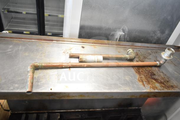 Garland Commercial 6 Burner Range with oven, over shelf, and back splash; visible wear and metal pipes on top.