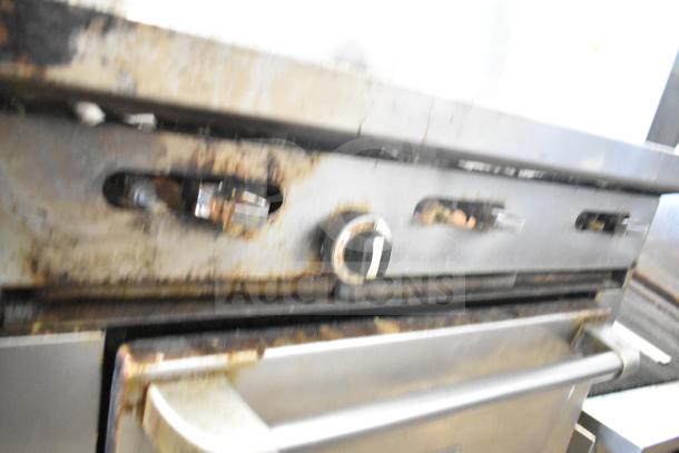 Garland Commercial 6 Burner Range w/ oven, over shelf, backsplash; visible wear and rust; stainless steel handle shown.