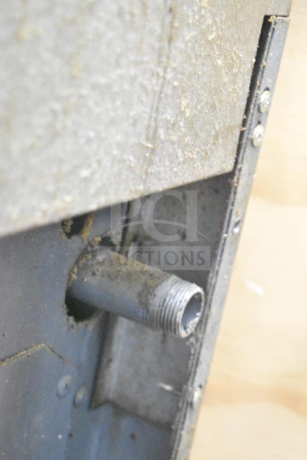 Close-up of a Garland commercial range component showing a threaded metal pipe, indicating possible wear.