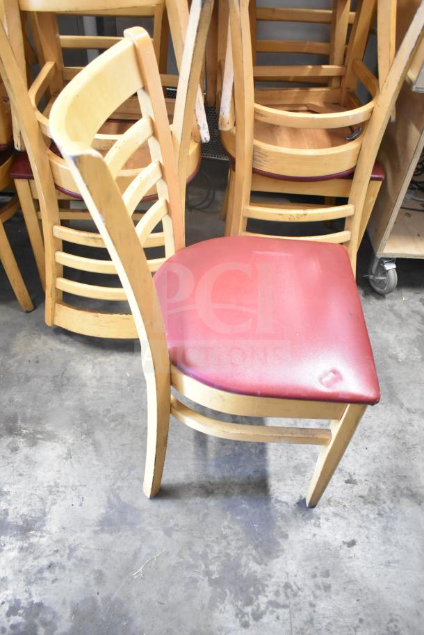 Wooden dining chair with maroon seat cushion. Sturdy design, gently used, set of 10 available for auction.