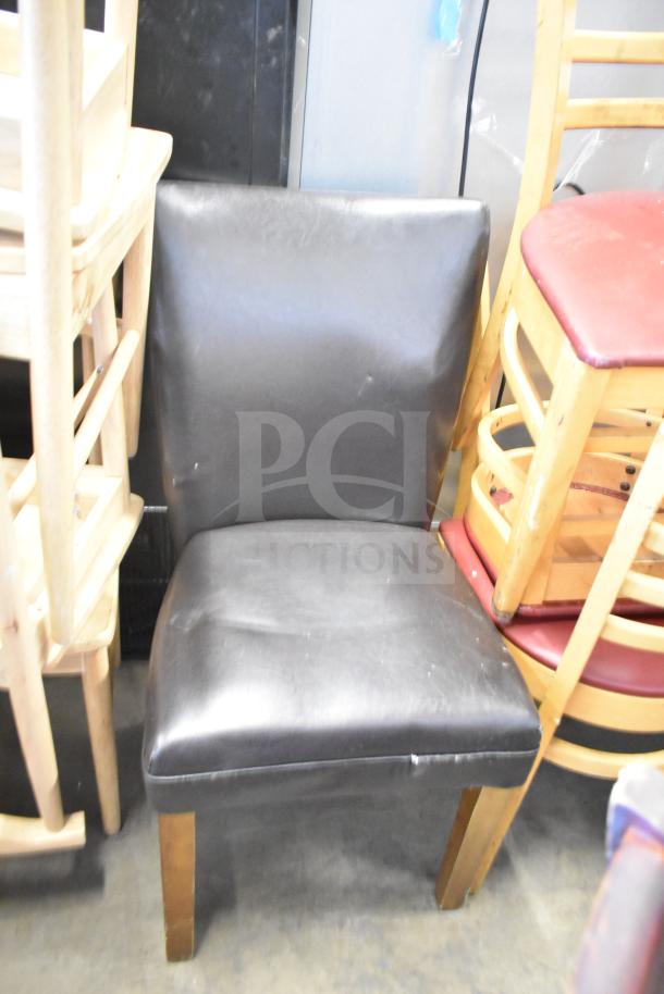 7 assorted chairs including high chair and dining chairs, various materials, visibly used. Some chairs stacked.