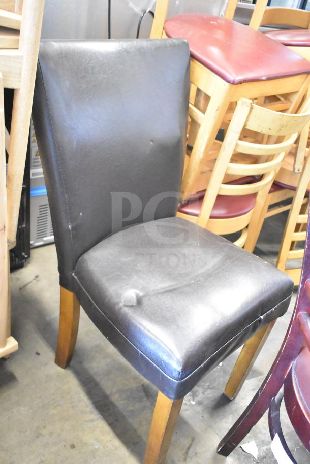 7-item auction lot with assorted chairs, including a black dining height chair with a faux leather finish and wooden legs.