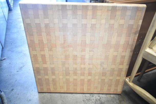 Square wooden tabletop with interlocking pattern, sturdy and well-crafted, in excellent condition, ideal for dining or crafting.