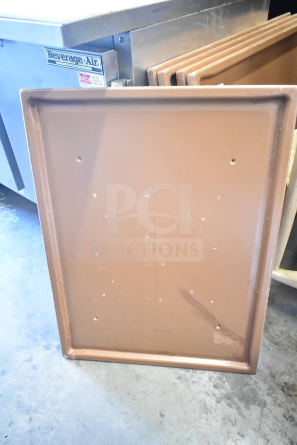 Set of 5 brown rectangular tabletops, lightly marked, in good condition, stacked upright.