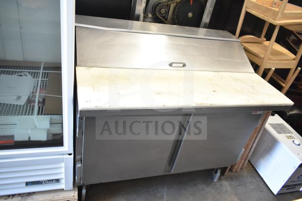 Beverage Air SP48-12C commercial prep table with stainless steel finish, mega top, and dual storage doors, showing wear.