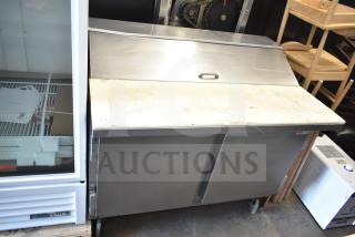 Beverage Air SP48-12C commercial prep table with stainless steel finish, mega top, and dual storage doors, showing wear.