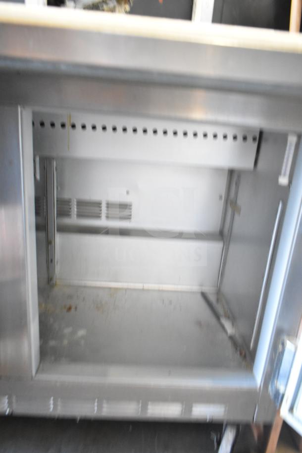 Beverage Air SP48-12C commercial prep table, visible storage interior, 115 volts, some wear, ideal for salad/sandwich prep.