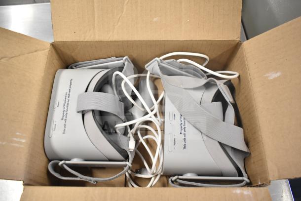Two Oculus MH-A64 VR headsets in a box with chargers, marked for use on Walmart property, gently used condition.