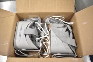 Two Oculus MH-A64 VR headsets in a box with chargers, marked for use on Walmart property, gently used condition.