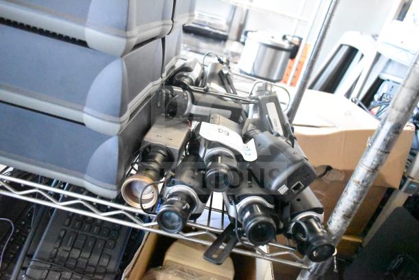 18 Bosch NBN-50022-C-W security cameras on a shelf, showing lenses and connectors. Tag number 66 visible.