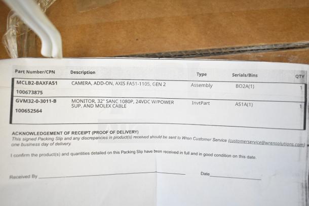 Packing slip showing a camera, AXIS FA51-1105, Gen 2, and 32" SANC 1080p monitor with power supply and Molex cable.