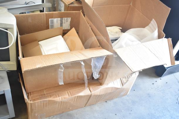 Cardboard boxes containing various metal items and packing materials, showing signs of wear. Includes shipping labels.
