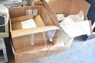 Cardboard boxes containing various metal items and packing materials, showing signs of wear. Includes shipping labels.