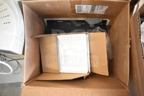 Cardboard box containing various metal pieces, packaged partially with foam. Shipping label visible on box exterior.