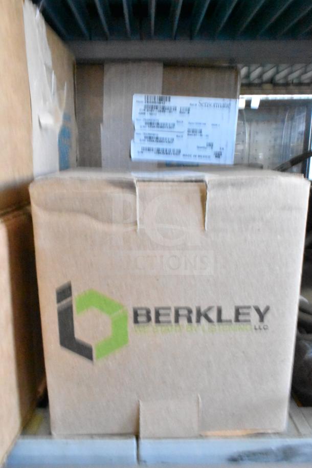 Cardboard box labeled "Berkley" with visible Sensormatic label, part of a 12-item auction including security antennas and camera.