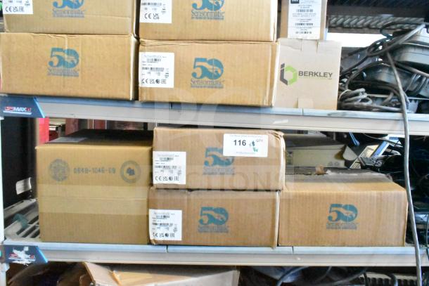 Boxes containing 8 Sensormatic security devices, including ZBAMB9010-IPS deactivator, ZBAMB9012 label antenna, and ZBSMPCPE compact pad, shown on warehouse shelving.
