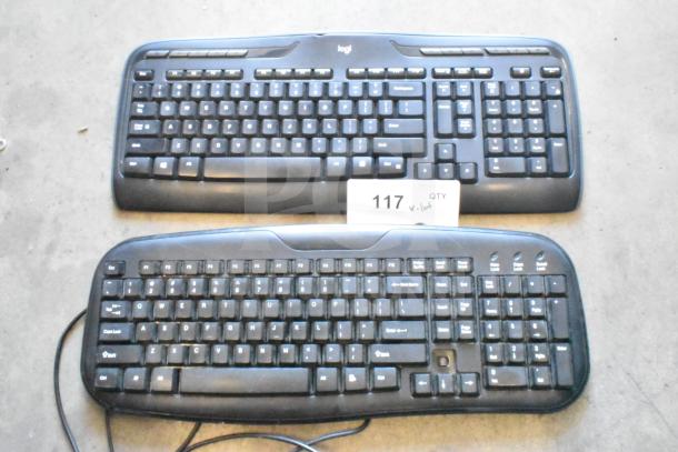 Lot including two Logitech keyboards, one wireless and one wired, both in used condition. Auction tag 117 visible.